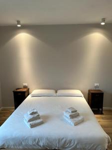 a white bed with three towels on top of it at Azienda agrituristica Scotti in Somma Lombardo