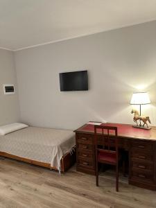 a bedroom with a desk with a bed and a desk with a chair at Azienda agrituristica Scotti in Somma Lombardo