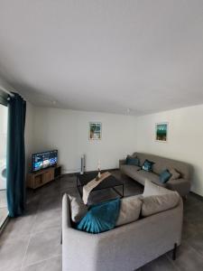 uma sala de estar com um sofá e uma mesa em Appartement neuf 4/6 personnes, près de la plage em Les Trois-Îlets