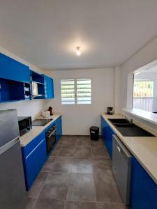 una cocina con armarios azules y encimeras azules en Appartement neuf 4/6 personnes, près de la plage en Les Trois-Îlets