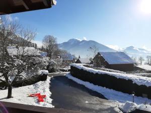 un patio cubierto de nieve con una casa y un árbol en Chambre Cocooning, en Viuz-en-Sallaz