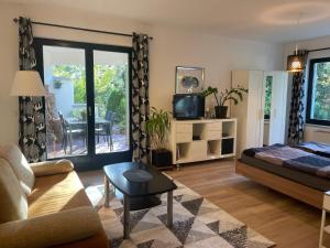 ein Wohnzimmer mit einem Bett und einem Sofa in der Unterkunft Apartment Frohnau in Berlin