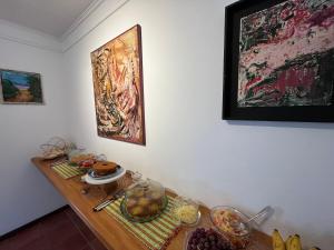 une table avec de la nourriture et des peintures murales dans l'établissement Casa Arte Cabore, à Parati