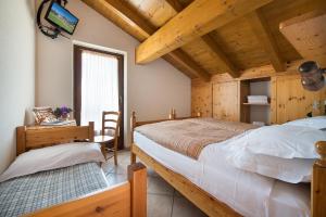 a bedroom with a bed and a desk and a tv at Hotel Gallo Cedrone in Valdisotto