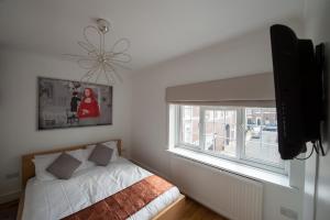 een slaapkamer met een bed en een raam bij Mayfair Town House in Londen