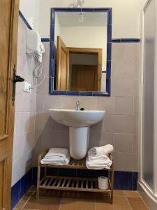 a bathroom with a sink and a mirror and towels at El traslado alojamiento rural in El Rocío