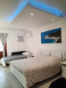 een slaapkamer met twee bedden en een schilderij aan de muur bij IL CUORE DEL CONERO - CASALE CON PISCINA, Natura e Relax in Camerano +73 foto's