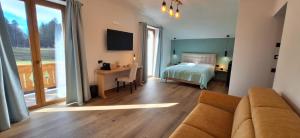 ein Wohnzimmer mit einem Sofa, einem Bett und einem Schreibtisch in der Unterkunft IL RIFUGIO DI GASTONE - Monte Amiata - in Castel del Piano