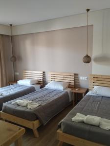 a bedroom with two beds and two tables at Cavo D'oro Beach Hotel in Kavos