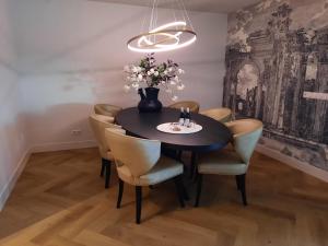 - une table à manger avec des chaises et un vase fleuri dans l'établissement Bij de Haven op Urk, à Urk