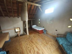 Zimmer im Dachgeschoss mit einem Bett und einem Sofa in der Unterkunft Casa ecológica in Funes
