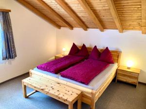 a bedroom with a large bed with red pillows at Chasa Sot-Chaunt 301 in Samnaun