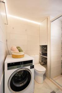 a bathroom with a washing machine and a toilet at Olive Garden Residence in Platanes