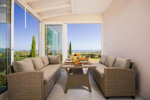 a living room with a couch and a table in front of a window at Olive Garden Residence in Platanes