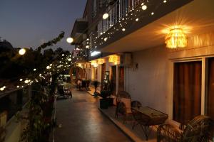 eine Terrasse mit Stühlen und Licht an einem Gebäude in der Unterkunft LARA BOUTIQUE HOTEL Antalya in Lara