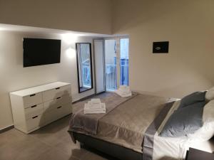 a bedroom with a bed and a dresser and a television at Le Case di Rita in Naples
