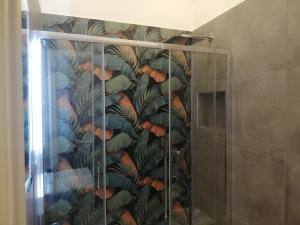 a shower stall with a mural of leaves at Le Case di Rita in Naples