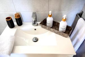 a bathroom sink with three bottles of soap on it at Seaside Serenade 1, suite in Ermoupoli +31 photos