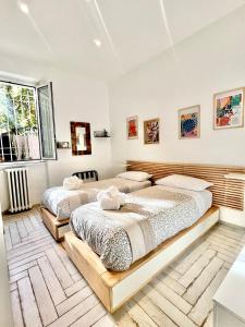 Duas camas num quarto com paredes brancas em Roma Caracalla apartament with garden em Roma