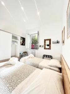 2 letti in una camera da letto con pareti bianche di Roma Caracalla apartament with garden a Roma