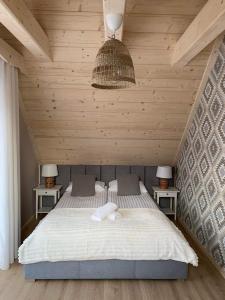 ein Schlafzimmer mit einem Bett mit zwei Nachttischen in der Unterkunft Uroczy drewniany domek - Domki pod Brzegiem in Zakopane