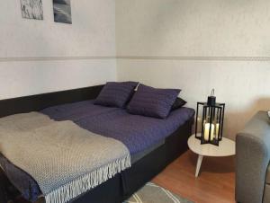 een bed met paarse kussens in een kamer bij Spacious apartment with balcony and free WiFi in Rovaniemi