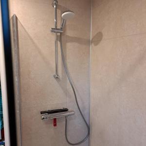 La salle de bains est pourvue d'une douche avec un pommeau de douche. dans l'établissement Zonnig zomerhuis, à Krachtighuizen
