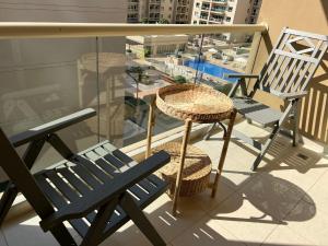 balcón con banco azul, mesa y sillas en Nice Location - 76 m2 en Dubái