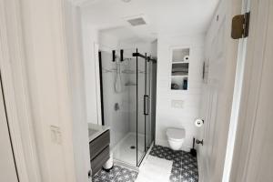 y baño blanco con ducha y aseo. en Owl Cabin - Cozy Forest Retreat nearby Lake en East Kemptville