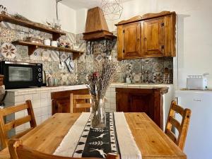una cocina con una mesa de madera con un jarrón. en Baita delle Rocche, en Rocca di Mezzo
