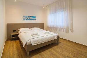 1 dormitorio con 1 cama con sábanas blancas y ventana en CITY LIFE with free parking en Pula