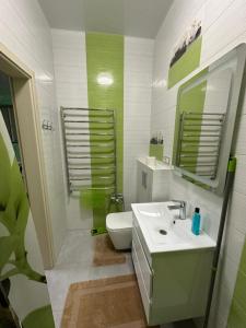 La salle de bains est pourvue d'un lavabo, de toilettes et d'un miroir. dans l'établissement Днестровский, à Kharkov