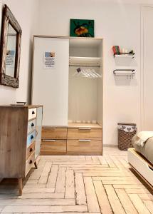 ein Schlafzimmer mit einer Kommode und einem Spiegel in der Unterkunft Roma Caracalla apartament with garden in Rom