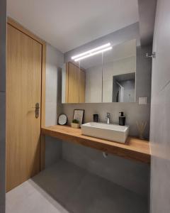 een badkamer met een wastafel en een spiegel bij Athens Cosy Semi-Basement Apartment in Athene