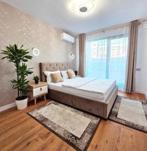 een slaapkamer met een bed en een groot raam bij Luxury Apartment in Boekarest