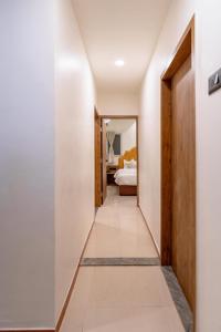 einen Flur, der zu einem Schlafzimmer mit einem Bett führt in der Unterkunft hotel silver tree in Rajkot