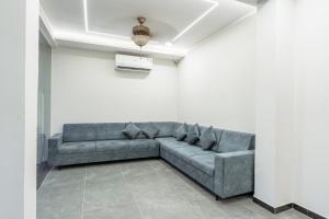 a living room with a gray couch in a white room at hotel silver tree in Rajkot