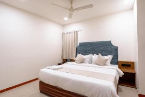 ein Schlafzimmer mit einem großen Bett mit weißer Bettwäsche in der Unterkunft hotel silver tree in Rajkot
