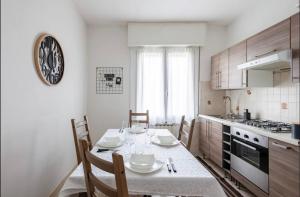 a kitchen with a table with chairs and a clock on the wall at Formigine - [Motor Valley-Homes] in Formigine