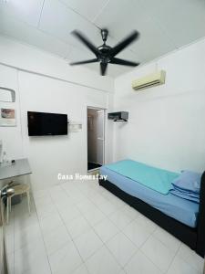 a bedroom with a bed and a ceiling fan at CASA Homestay in Batu Pahat