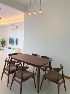 een eettafel met stoelen en een lamp bij Sekinchan Simple LoveSea House ~ Seaview 3-14AB in Sekincan