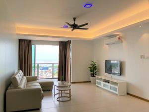 a living room with a couch and a ceiling fan at Sekinchan Simple LoveSea House ~ Seaview 3-14AB in Sekincan