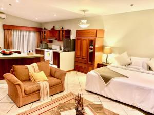 a bedroom with a bed and a couch and a kitchen at Casa Bella Boutique Hotel San Isidro in Lima