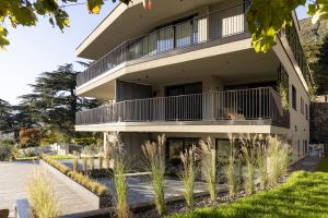Erbacher Living Nature Apartments Suites في بولسانو: عمارة سكنية مع شرفة ونباتات