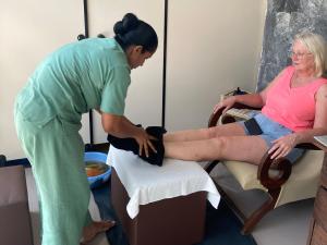 a woman sitting in a chair getting her leg examined at Handagedara Resort & Spa in Mirissa