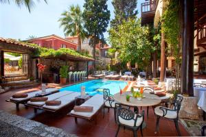 a patio with a pool and tables and chairs at Alp Pasa Hotel - Special Class in Antalya