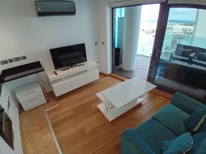 a living room with a couch and a flat screen tv at Hidden Gem at Luxurious Ocean Village in Gibraltar