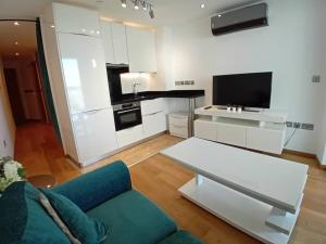 a living room with a blue couch and a kitchen at Hidden Gem at Luxurious Ocean Village in Gibraltar