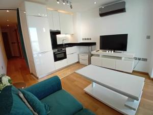 Il comprend un salon avec un canapé bleu et une cuisine. dans l'établissement Hidden Gem at Luxurious Ocean Village, à Gibraltar