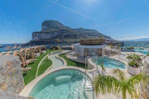 a resort with a pool with a mountain in the background at Hidden Gem at Luxurious Ocean Village in Gibraltar